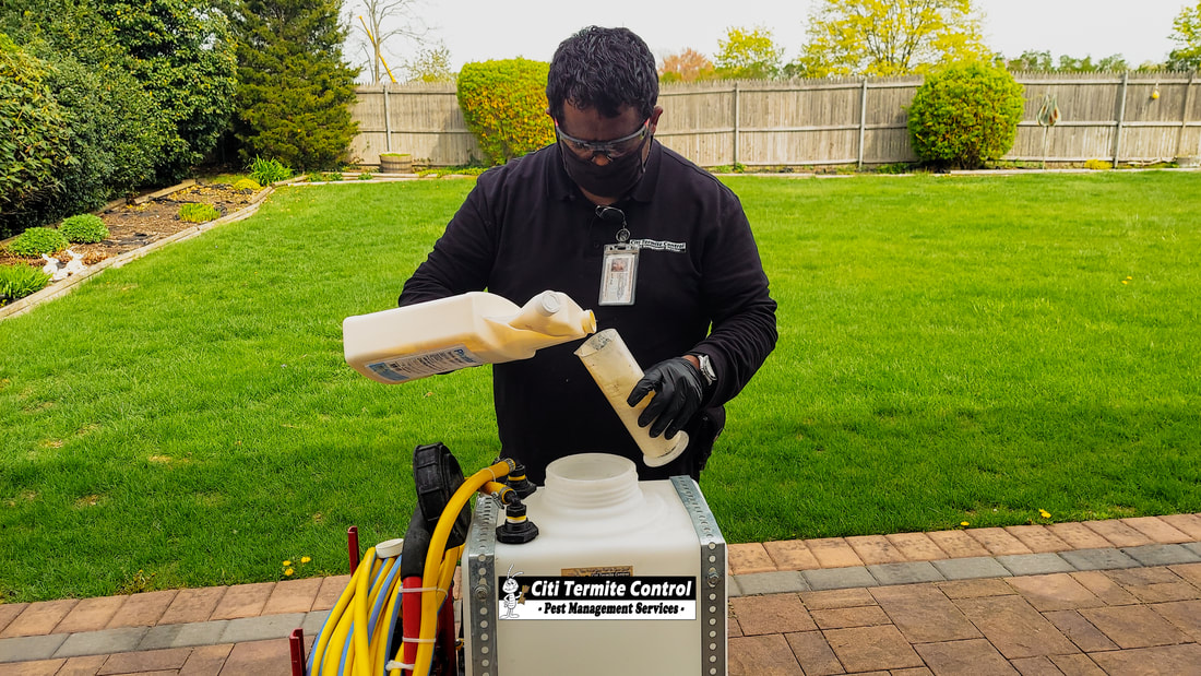 A Pest Control Technician mixing products for a Termite treatment around a home.